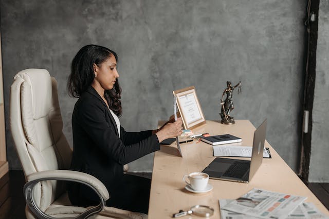 a lawyer in a black suit looking over document at their desk